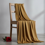 Create an image of wash n wear fabric in dull mustard colour and open fabric leane on wodden chair and rose floer on left side chair